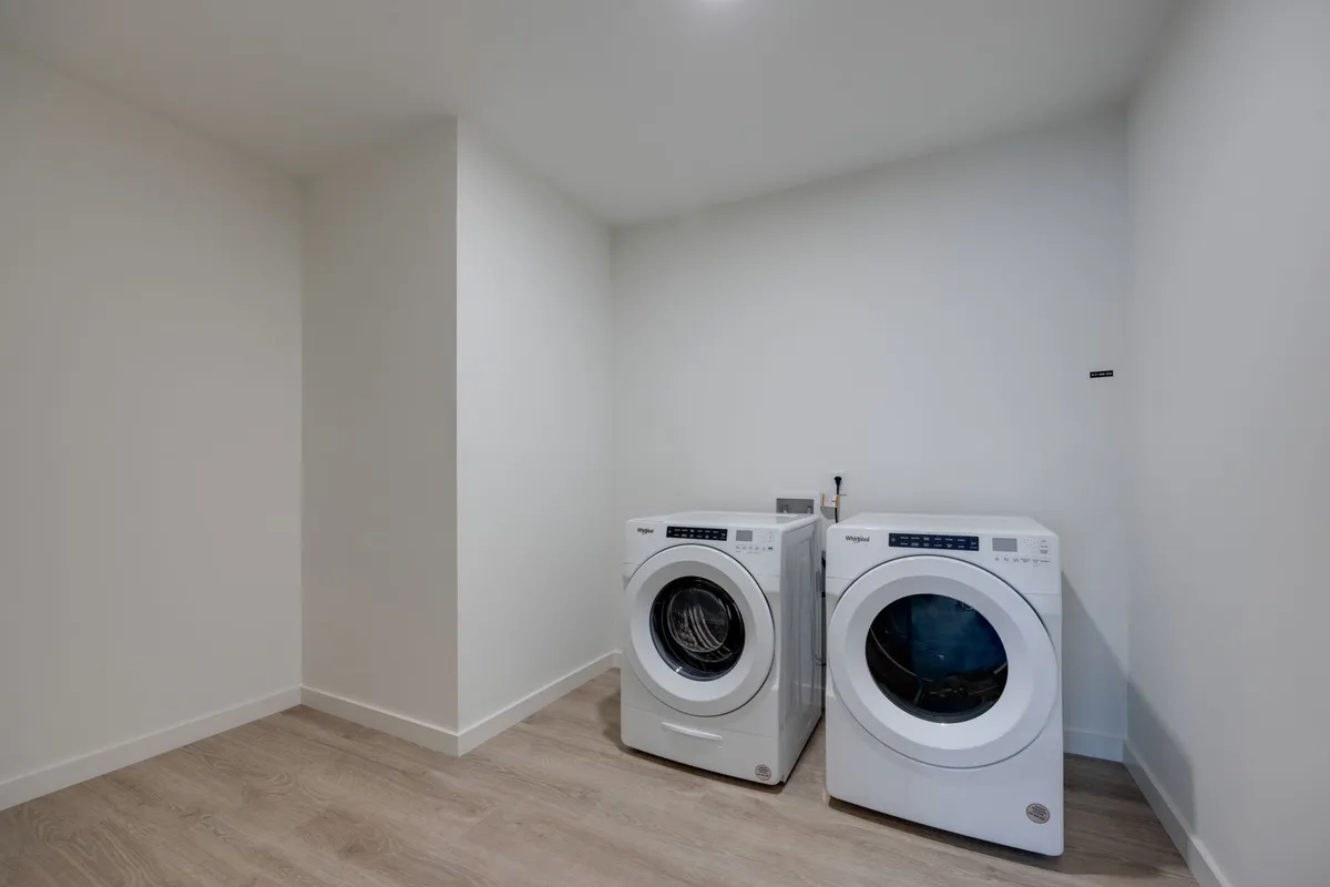 A practical laundry area with a washing machine and dryer, highlighting organizational efficiency and the ability to keep clothes fresh during extended stays.