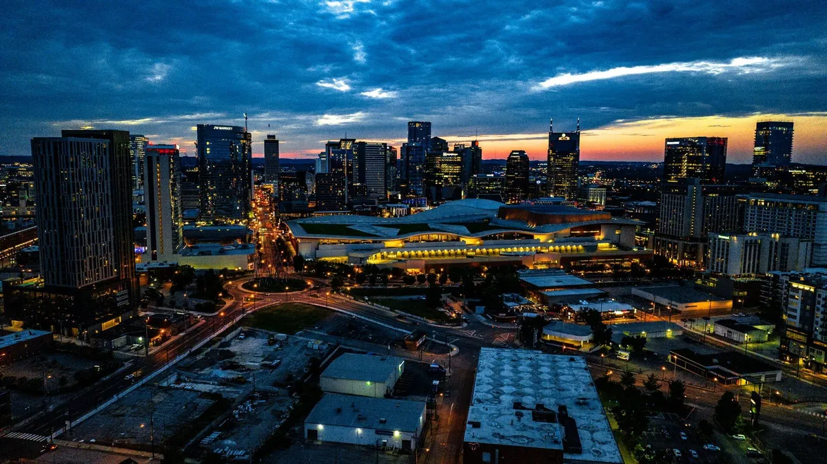 This exterior image looks out over Nashville’s city skyline at dusk, with illuminated buildings and active roadways. The dynamic view captures the energy and accessibility of the city’s hottest spots just steps away.