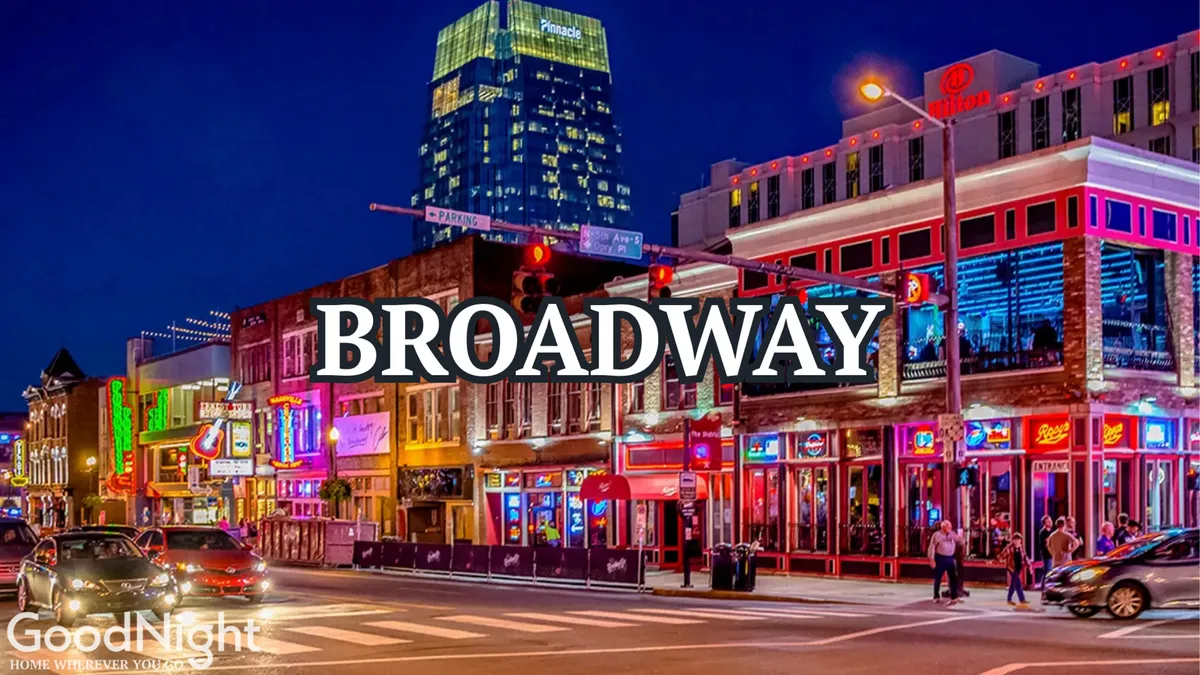 A vibrant nighttime street scene featuring neon signs, lively crowds, and colorful storefronts, all set in a bustling city environment indicative of Nashville's famous Broadway district. The glow from the lights creates a festive and energetic atmosphere, inviting exploration and nightlife adventures.